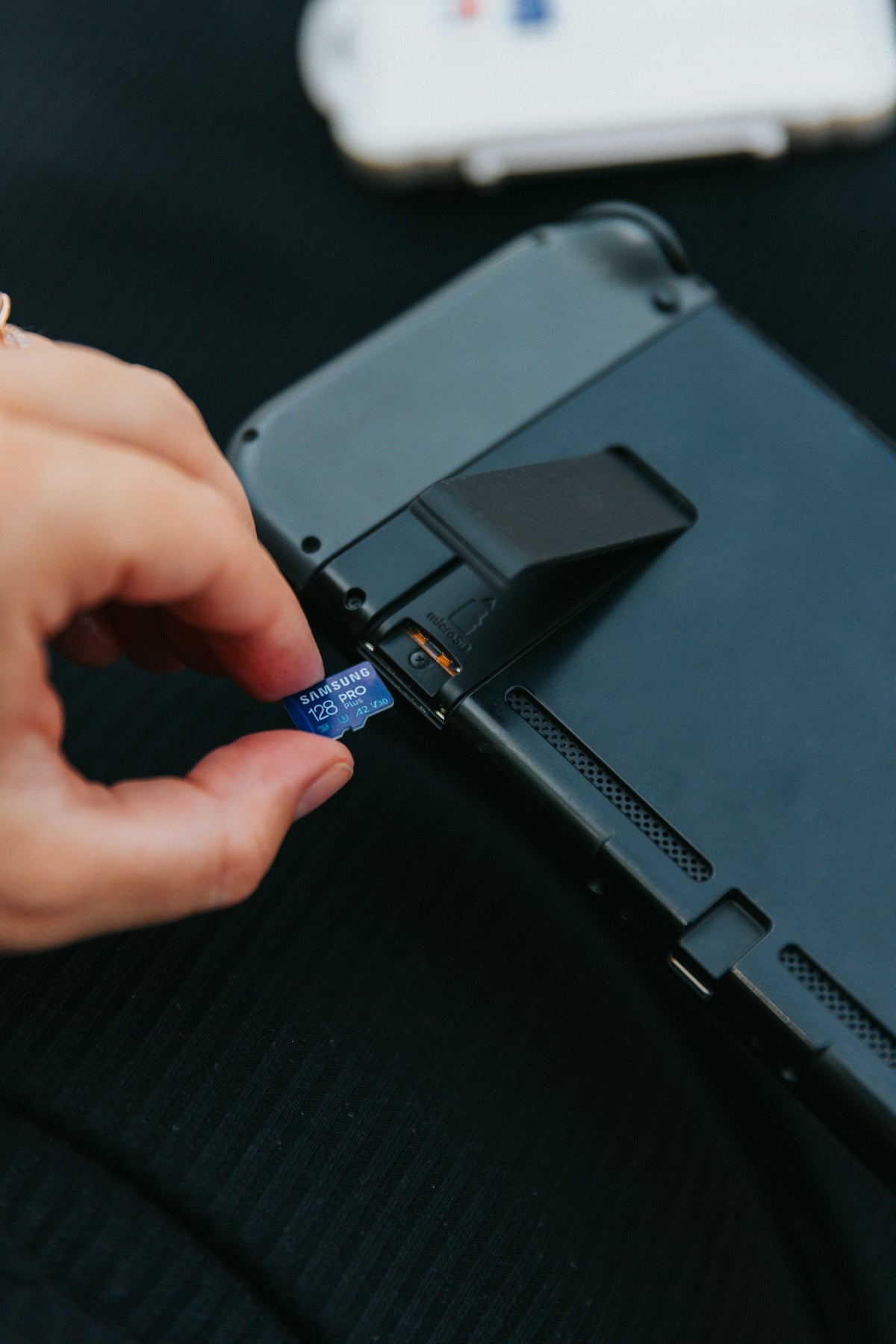 a hand holding a black rectangular device