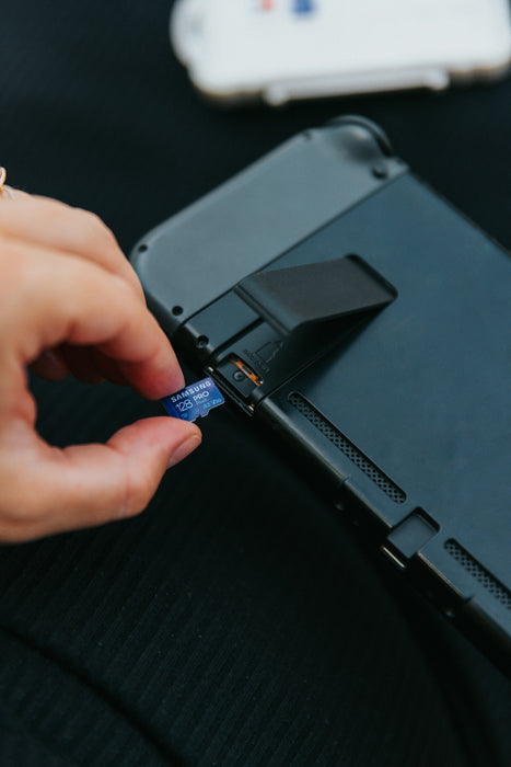a hand holding a black rectangular device