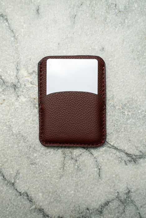 A brown cardholder with a white card inside.