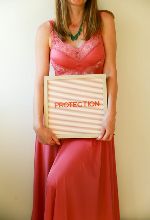 A woman holds a sign that reads protection.
