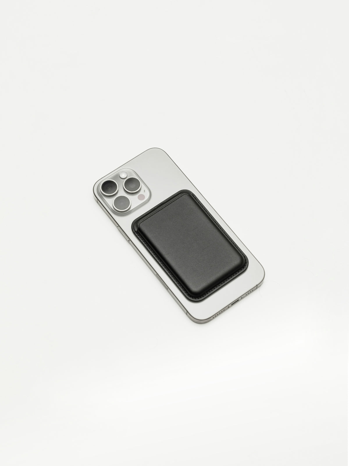 Silver smartphone with black magnetic wallet on a white background.