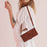 For iPhone 17 Skin Feel Heart Embossed Leather Phone Case with Long Lanyard(Brown)